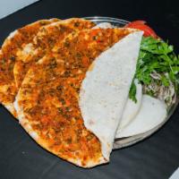 Lahmacun · A traditional dish of very thin layers of dough topped with a blend of ground lamb, tomatoes...