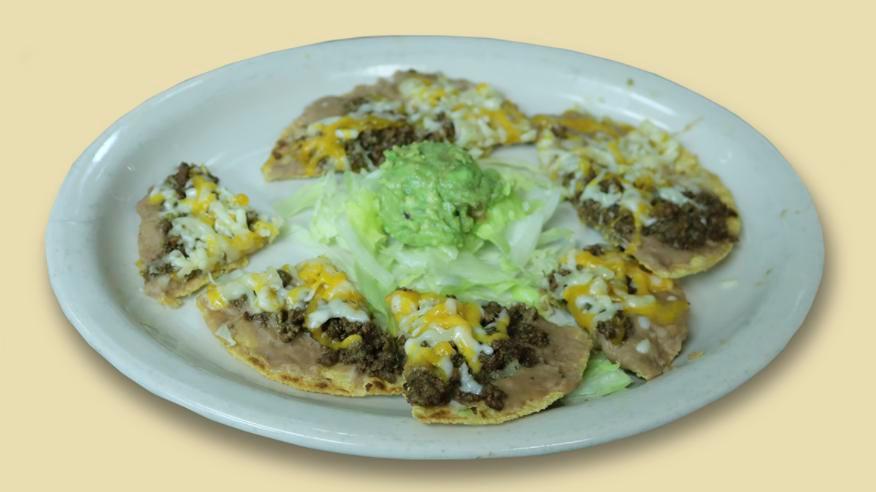 Fajita Nachos · 2 corn tortilla topped with your choice of chicken or beef fajita refried beans and cheddar cheese. Garnished with sour cream, guacamole, and jalapenos.