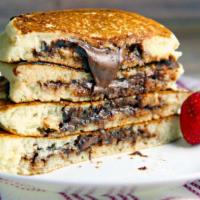 NUTELLA PANCAKES · Golden round pancakes topped with Nutella