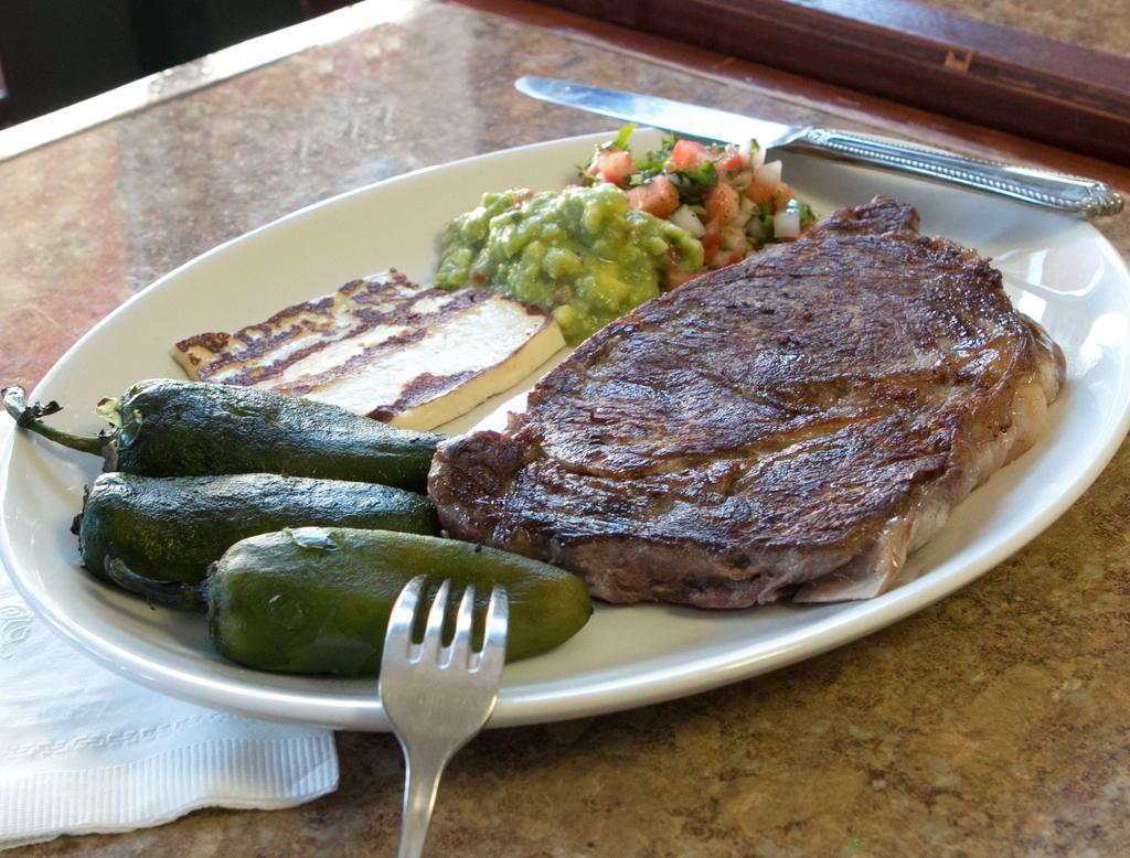 Bistec Poblano · Grilled rib eye steak, guacamole, pico de gallo, queso blanco and grilled jalapeno peppers. Served with rice, beans and tortillas.