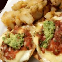 Eggs Rancheros · Crispy tortilla, guacamole, refried beans, cheddar, Monterey Jack, over easy eggs and fresh ...