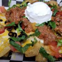 Pan Nachos · A mound of fresh fried corn tortilla chips topped with cheddar jack cheese, diced tomatoes, ...