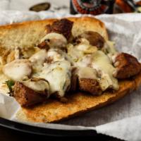 The San Gennaro Feast Hero · Grilled, hot Italian sausage chopped with sauteed onions and green peppers, dripping with me...