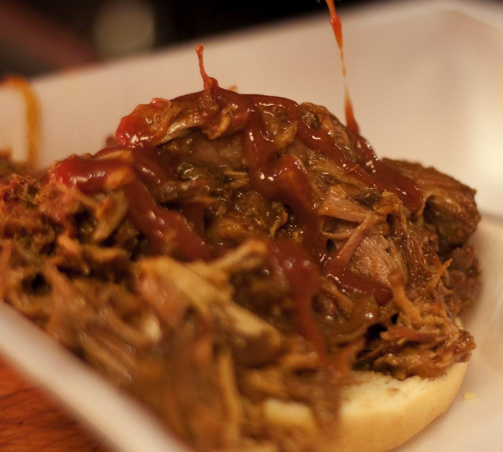 Pulled Pork · Pork Shoulder Slow Cooked in Au Jus, BBQ Sauce, Vinegar, Onions & Spices, Served on a Bun. Ask to top it with Raw Onions, Pickles, BBQ Sauce, and/or Cole Slaw.  