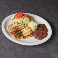 Pechuga a la Plancha · Chicken breast sauteed with onions, white wine and butter. Served with rice and beans, house...