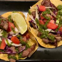 Steak Taco · Marinated steak with onions & tomatoes grilled to perfection with crunchy cabbage, diced tom...