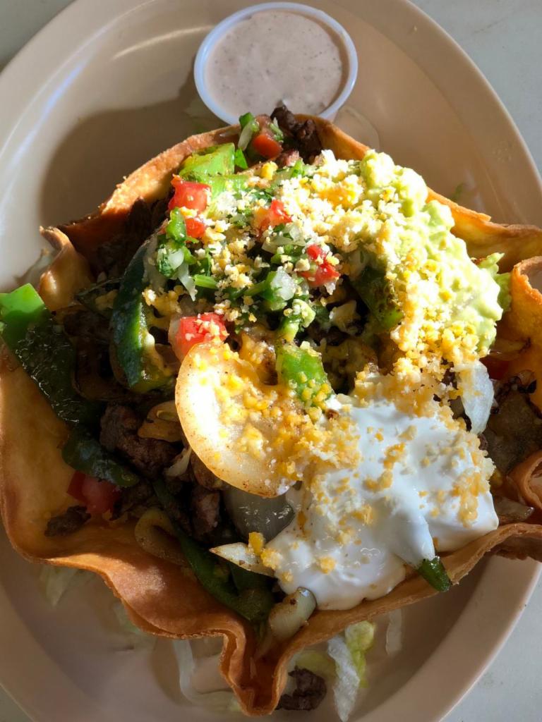 Fajita Salad · Fried tortilla shell stuffed with lettuce, choice of meat, topped with cheese, guacamole, sour cream, and pico de galo.