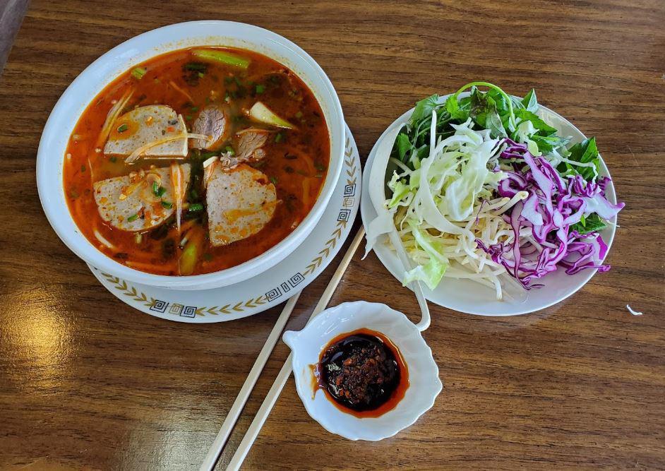 Spicy Beef Noodle Soup · Bun bo hue. a spicy central Vietnamese beef soup with lemongrass flavor. Thick rice noodles, slices of marinated beef shank or flank, slices of pork hock ham in a bowl of spicy broth. Served with the dish of mixture of shredded cabbage and bean sprouts.
