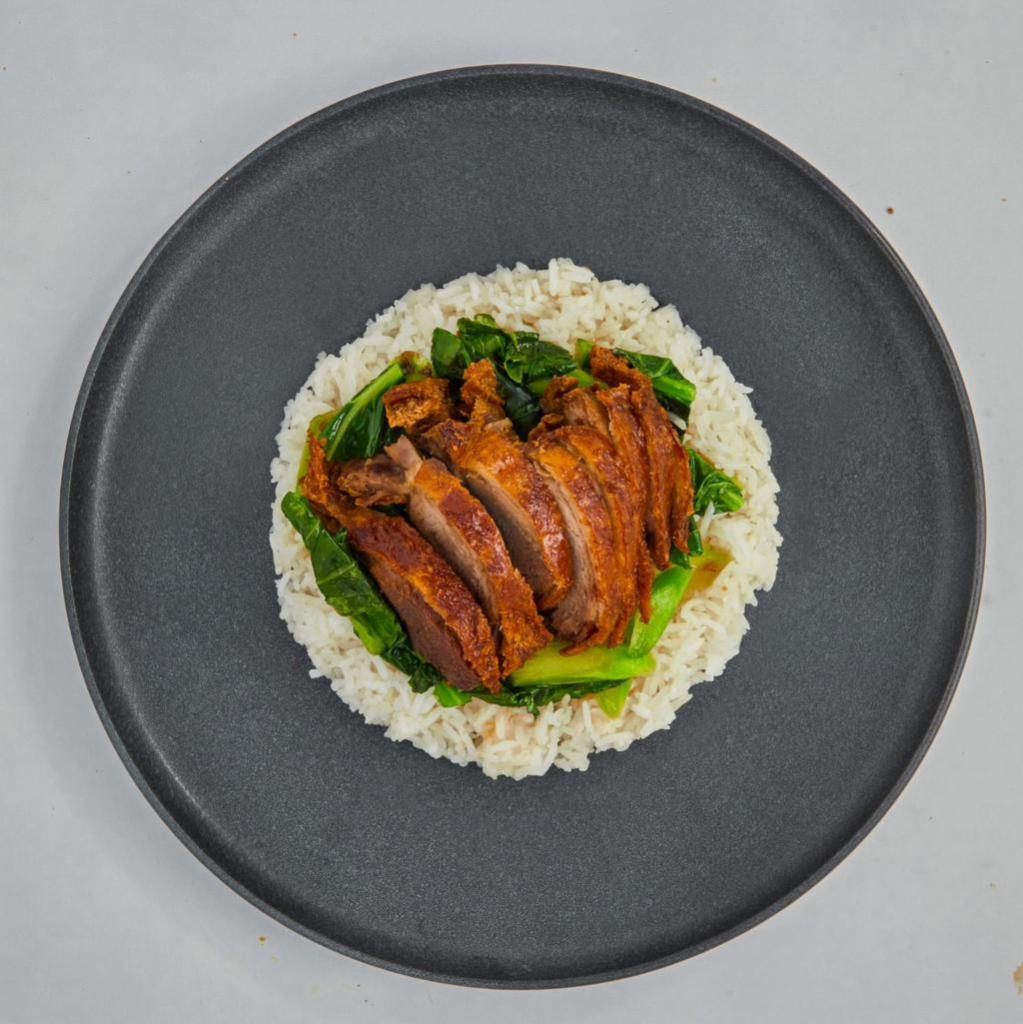 Crispy Duck Over Rice · Roasted crispy boneless half duck with chinese broccoli, topped with duck soy sauce. Served with white rice.