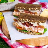 Turkey Club · A turkey club sandwich made with our thin sliced smoked turkey, bacon and swiss with lettuce...
