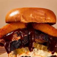 Brisket Sandwich · Slow smoked brisket topped with pickle, onion rings, coleslaw and our house BBQ sauce.