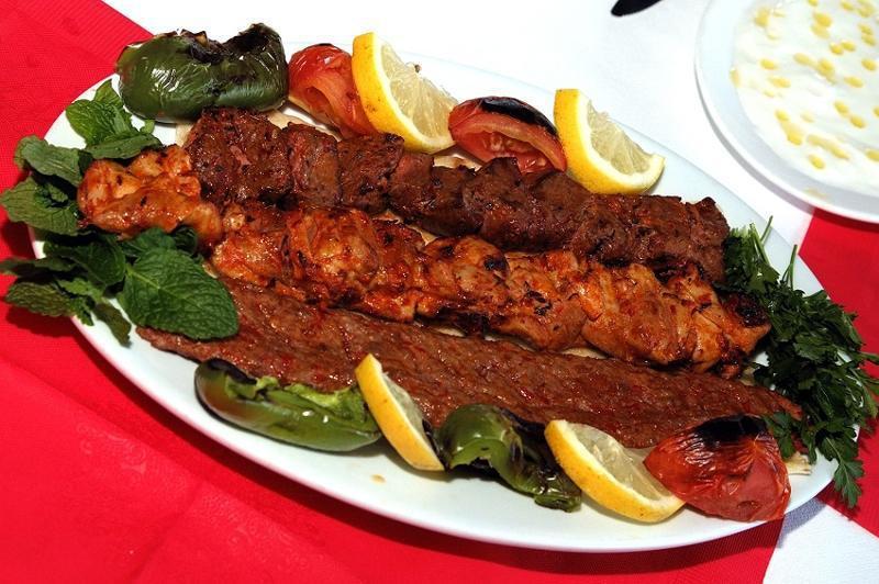 29. Mix Adana Kebab · Char-grilled chicken and lamb skewers seasoned with Turkish spices and served with rice and salad.