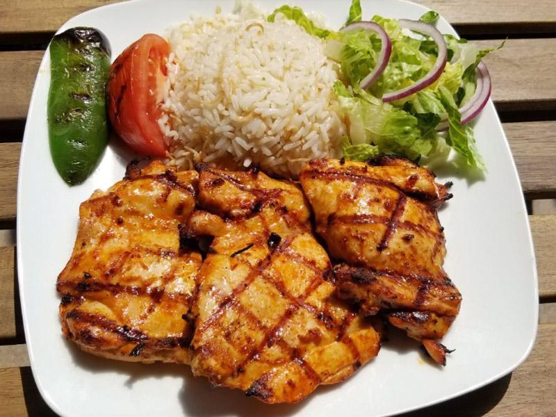 33. Chicken Chops · Char-grilled chicken thighs served with rice and salad.