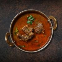 Parliamentary Lamb Curry  · Pieces of lamb sauteed with fresh garlic, ginger, and tomatoes served with a side of aromati...