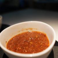 Salsa Roja · Red house-made salsa with tomatoes, guajillo, chipotle, onion, garlic, and jalapenos. Hot in...