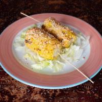 Elote Asado · Grilled corn on the cob with Mexican mayonnaise, chili piquin and cotija cheese.