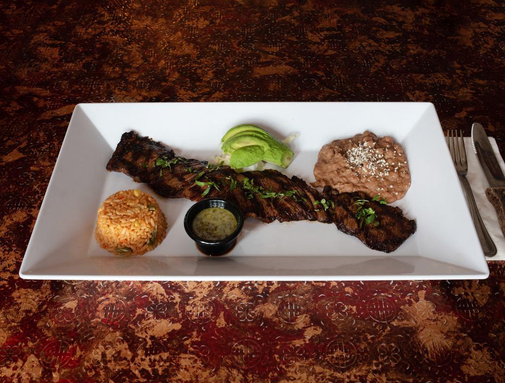 Grilled Skirt Steak · Skirt steak with chimichurri sauce. Served with rice and beans and sliced avocado.