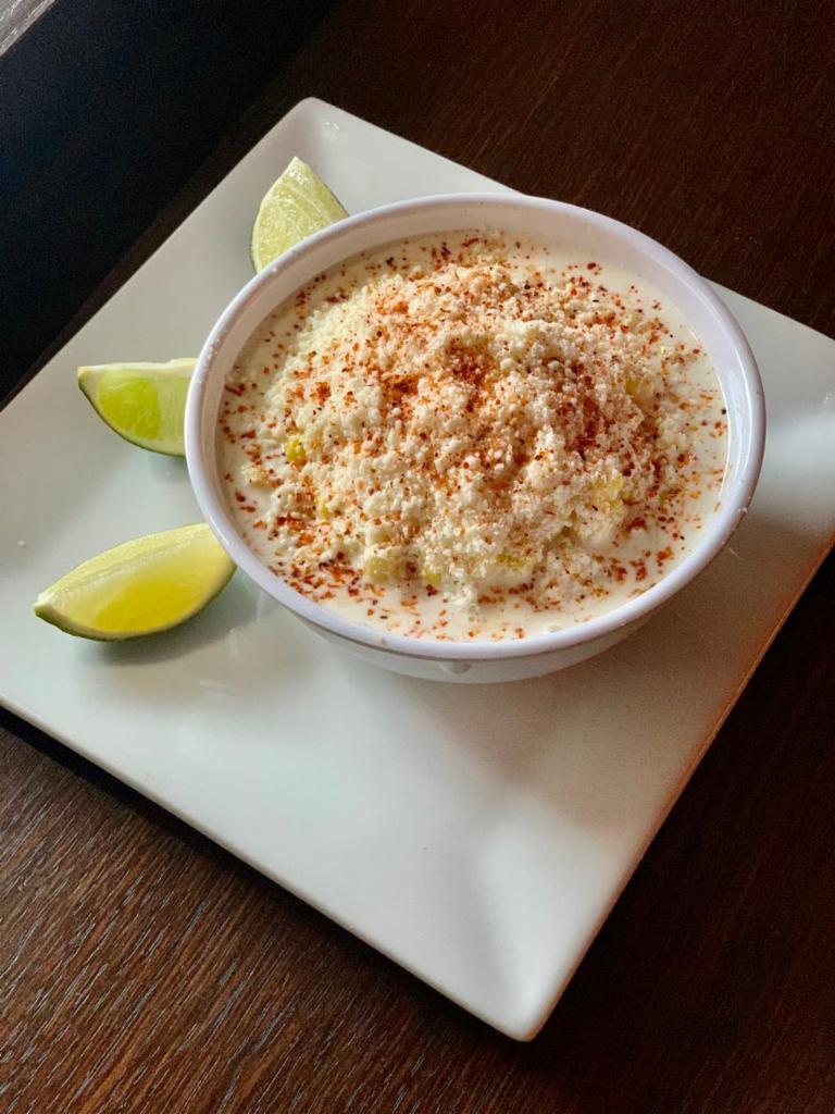 Esquite · Corn kernels, chile Tajín, mayo, Sour cream, Cotija cheese and lime juice

