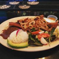 Bistec Encebollado · Steak topped with onions and tomato sauce. Served with rice and choice of side (beans, fries...