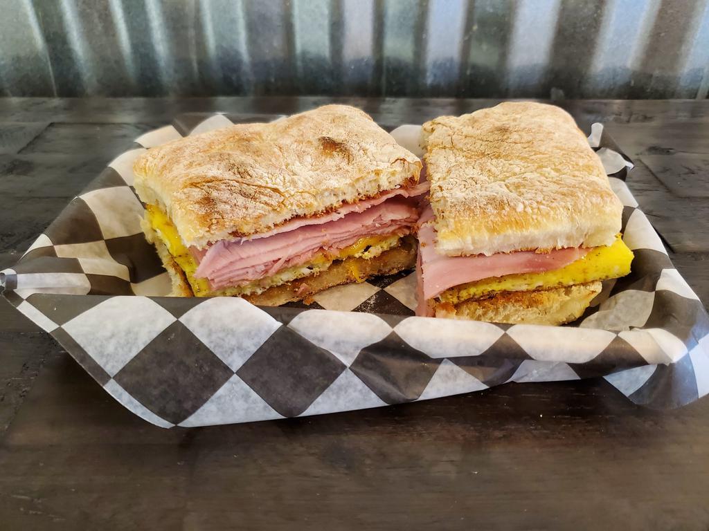 Ciabatta Breakfast Sandwich · A toasted house-made ciabatta roll, buttered, then layered with eggs, and your choice of sausage, ham, bacon, or roasted veggies.