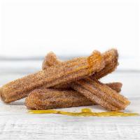 House Made Churros · Strips of fried dough filled with cajeta, dusted with sugar and cinnamon.