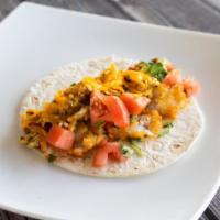 Breakfast Taco · Scrambled eggs, bacon, onions, hash browns, tomatoes, cheddar cheese, and fresh cilantro in ...