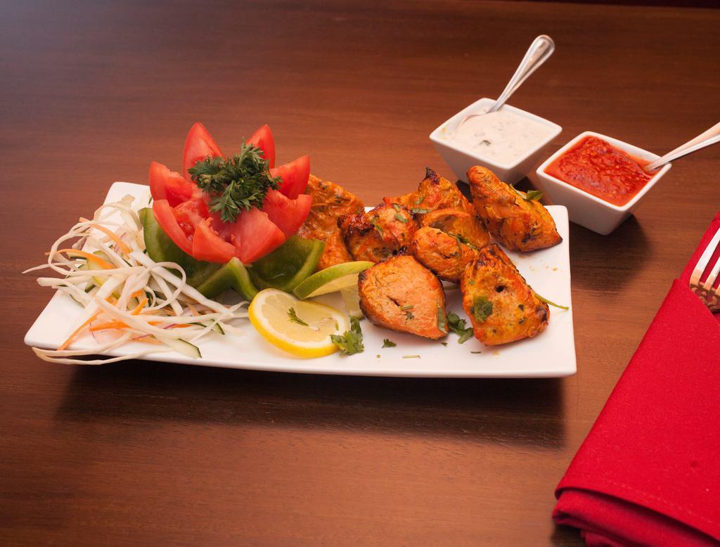 Tandoori Chicken Tikka · Boneless chicken marinated in herbs and spices, barbecued over charcoal.