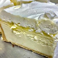 Lemon Curd & Creme Cheesecake - Slice · Packaged and sealed lemon cheesecake with a lemon curd and lemon whipped cream on top of a v...