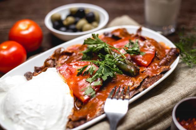 Alexander Kebab · Iskender. Turning grilled meat served with plain yogurt and tomato sauce, grilled tomatoes, pepper over turkish bread.