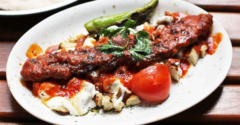 Yogurt Lamb Adana · Skewers of grounded lamb with garlic yogurt and tomato sauce, grilled tomatoes and pepper over turkish bread.