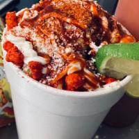Elote con hot cheetos preparados  · Large corn with crumbled hot Cheetos with mayo and hot sauce and corn chili powder and cotij...