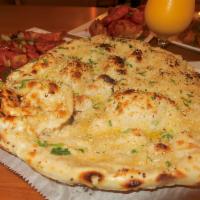 Naan · Indian flatbread freshly baked in a clay oven. Gluten free for an additional charge. Add gar...