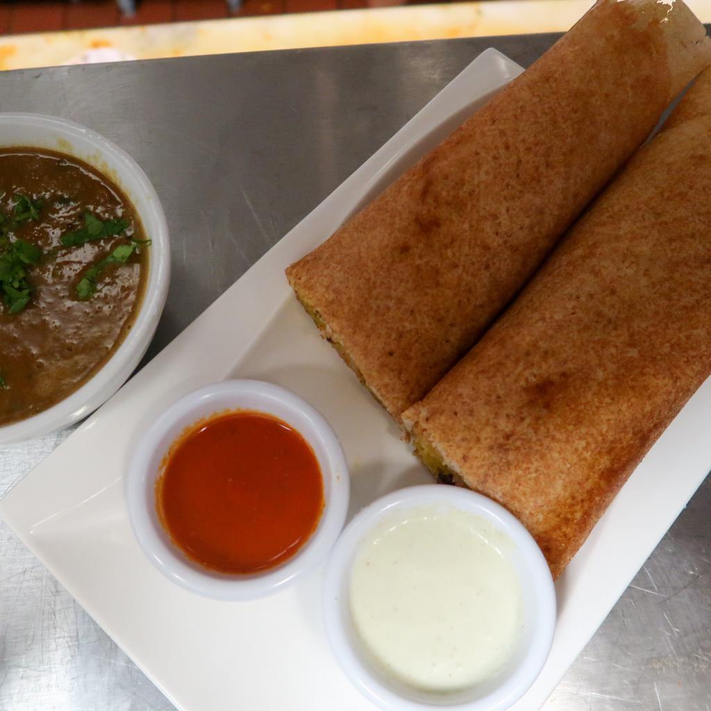 Dosa · Crispy grilled rice and lentil crepe, served with Sambar(lentil soup) and your choice of stuffing. Vegan, gluten friendly.