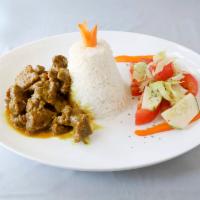 Curry Goat · Includes a side of white rice or rice and peas and salad.