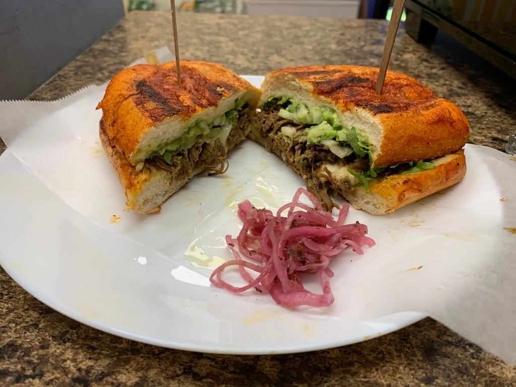 Torta birra de res · Just like the tacos de birra this torta is coated in red sauce with cheese and steak with a spread of guacamole // Como los tacos de birra esta torta esta roja con queso y birra con guacamole.