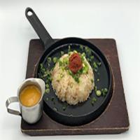 Spicy Fried Rice · Pork fried rice with green onions and egg shot
served table side in a piping hot iron skille...