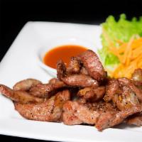 Sun-Dried Pork · Fried strips of pork marinated with Thai herbs, served with spicy sauce. 
