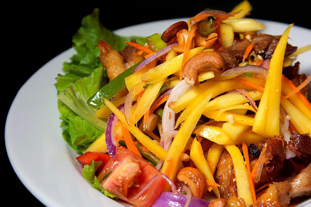 Duck Salad · Slices of crispy duck, sliced mango, tomato, onion, peanut and cashew nuts in tangy lime sauce.
