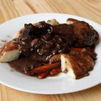 Le Coq au Vin Dinner · Chicken braised in red wine with mushrooms, pearl onions, carrots and potatoes.