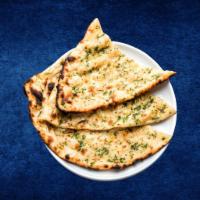 Garlic Naan · Fresh made leavened dough leaded with garlic and baked in a traditional coal oven. Vegetarian.
