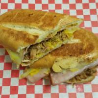 Cuban Sandwich · The Cuban sandwich consists of sliced seasoned roast pork, glazed ham, Swiss cheese, thinly ...