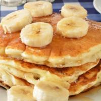 Golden Pancakes with Fresh Bananas · 3 Fluffy golden pancakes topped with fresh bananas. Served with a side of syrup and butter.