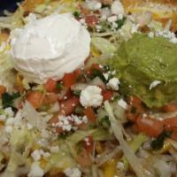Super Nachos · Our delicious nachos topped with beans, guacamole, sour cream, tomatoes and cheese.