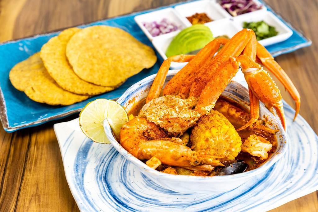 Seven Seas Soup · cod, mussels, octopus, langostino, shrimp, snow crab leg cluster, zucchini, squash, corn on the cob; served with tostada, avocado, cilantro, onion, oregano