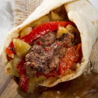 Adana Kebab Sandwich · Includes lettuce, tomato, onions and sauce.