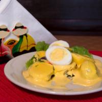 Papa a la Huancaina · Sliced baked potatoes topped with yellow Peruvian cheese cream sauce. 