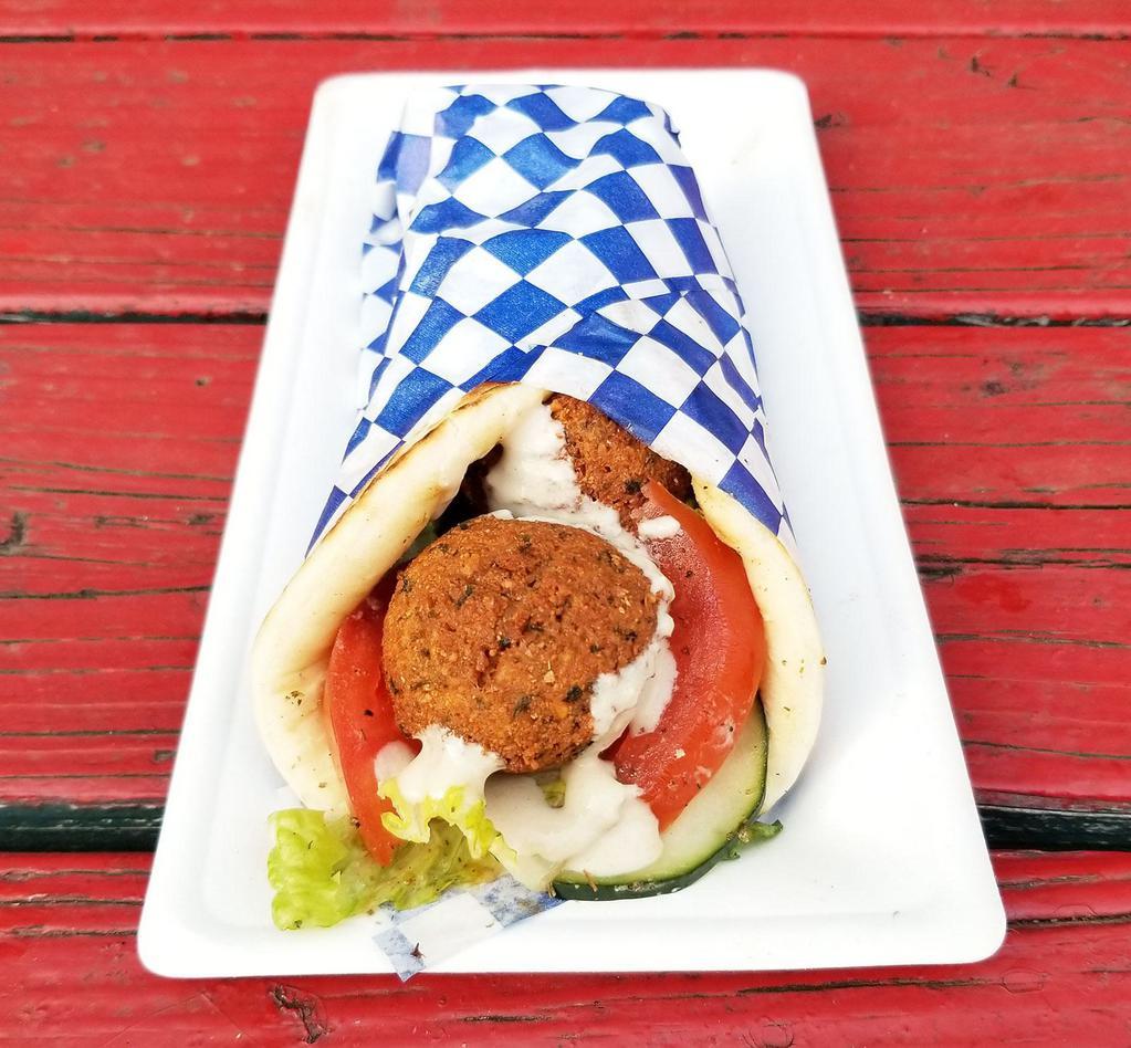 Spicy Falafel Pita · Spicy version of our popular falafel pita! Freshly fried falafel served on warm pita with lettuce, tomato, cucumber, onion, and choice of our harissa hot sauces!