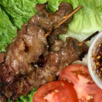 Moo Ping (Grilled Pork - 3 skewers) · A daily Thai favorite served w/ spicy jaew dipping sauce