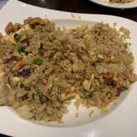 Pineapple Fried Rice · Stir-fried with sweet onions, pineapple chunks, and egg topped with cashew nuts, peas, and c...