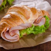 Croissant with Ham, Egg, and Cheese · Buttery and flakey croissant filled with fresh eggs, juicy ham, and melted cheese.